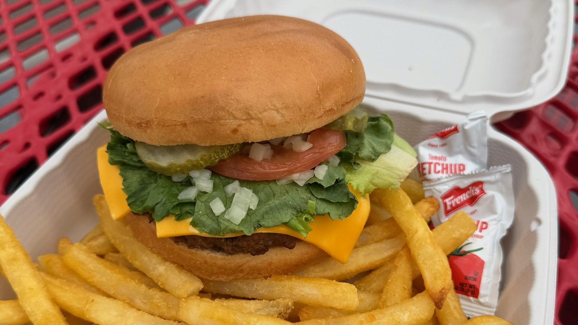 Cheeseburger with lettuce, tomato and pickles and a side of fries