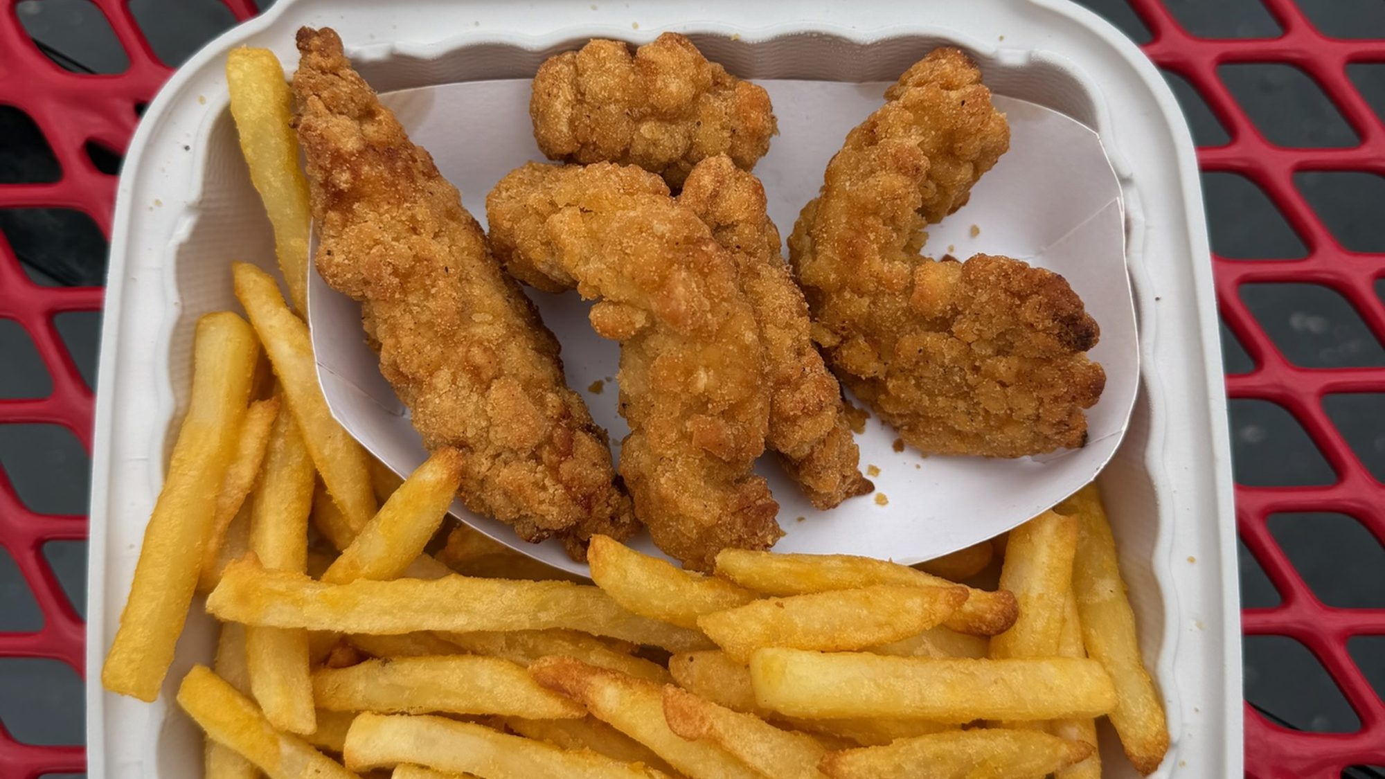 Chicken tenders and fries in a takeout box
